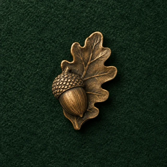 Acorn and Leaf Lapel Pin, front view on green felt
