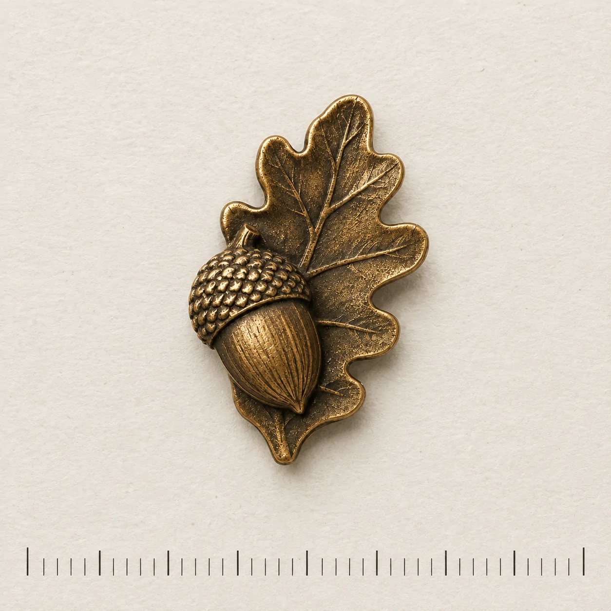 Acorn and Leaf Lapel Pin on a millimetre scale card