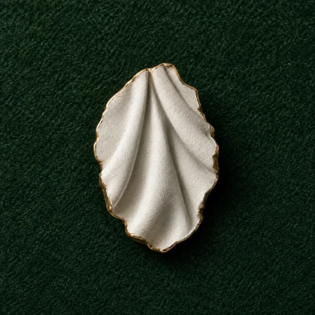 Drapery Fold Lapel Pin, front view on green felt