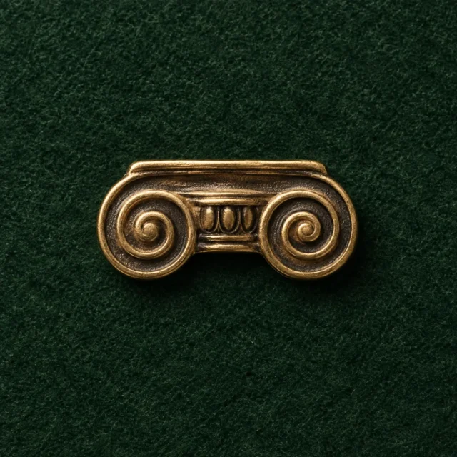 Ionic Volute Lapel Pin, front view on green felt