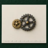 Twin Cogs Lapel Pin on a millimetre scale card